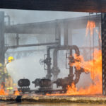 Fire fighters battling remains of a fire explosion at an oil refinery Fire fighters battling remains of a fire explosion at an oil refinery