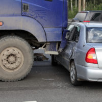 Large truck accident with car on busy road