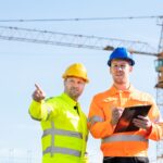 Two Male Architects Working On Construction Site