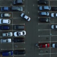 Drone footage cars parking at congested parking lots. people walking parking