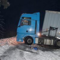 A real accident. Truck traffic accident at night, on a snowy winter road. Broken truck on the road in the snow.