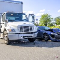 Road accident with damage to vehicles as a result of a collision between a semi truck with box trailer and a car