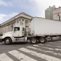 Huge white semi truck negotiating New York City intersection. Ho