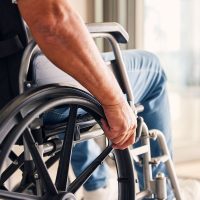 Man, hands and wheelchair for support, hope or travel in healthcare or medicare at home. Closeup of male or person with a disability moving on chair for mobility, surgery or wellness in the house.