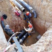 Construction workers risky their lives working inside deep trenches to install underground services pipe. Not following standard safety procedure.