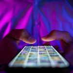man scrolling mobile phone screen in dark room with neon lights. internet browsing, social media and marketing man scrolling mobile phone screen in dark room with neon lights. internet browsing, social media and marketing