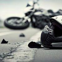 Motorcycle crash road accident with broken motorbike and helmet. City background. Banner with copy space.