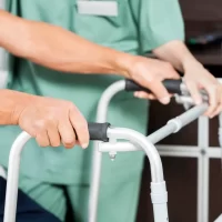 Patient's Hands Holding Walker By Nurse In Rehab Center
